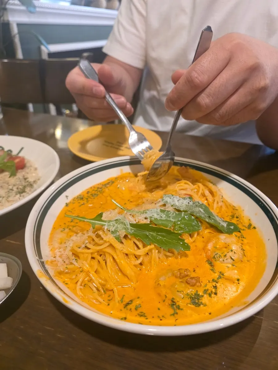 Half-eaten plate of rosé pasta
