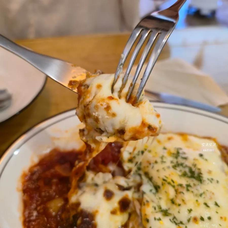 A bite-sized portion of lasagna scooped out