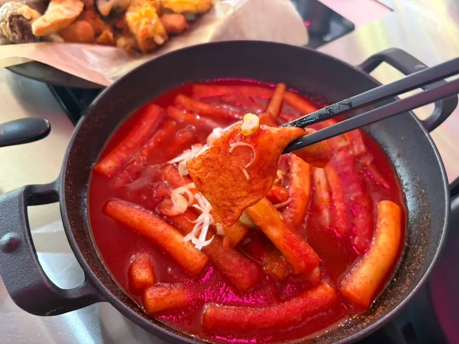 辣炒年糕、炸物與飯捲一同擺放的餐桌