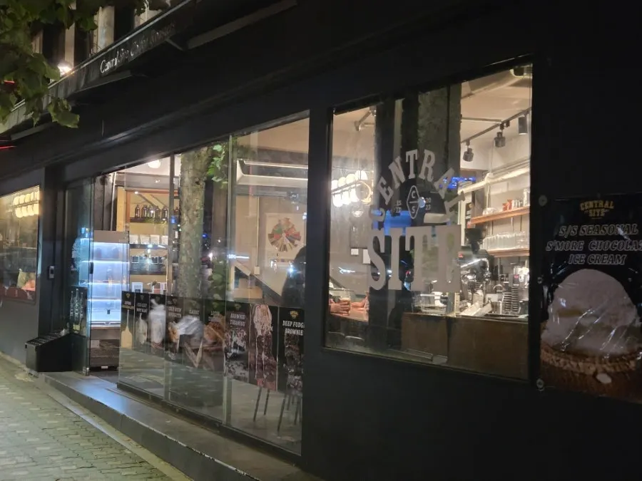 Black-toned café exterior on a night street