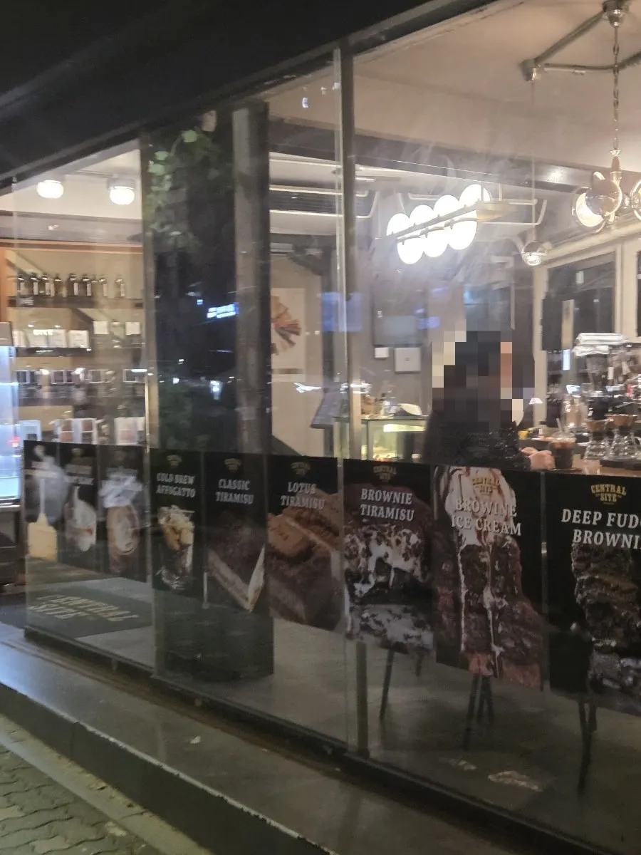 Café exterior with floor-to-ceiling windows and warm lighting