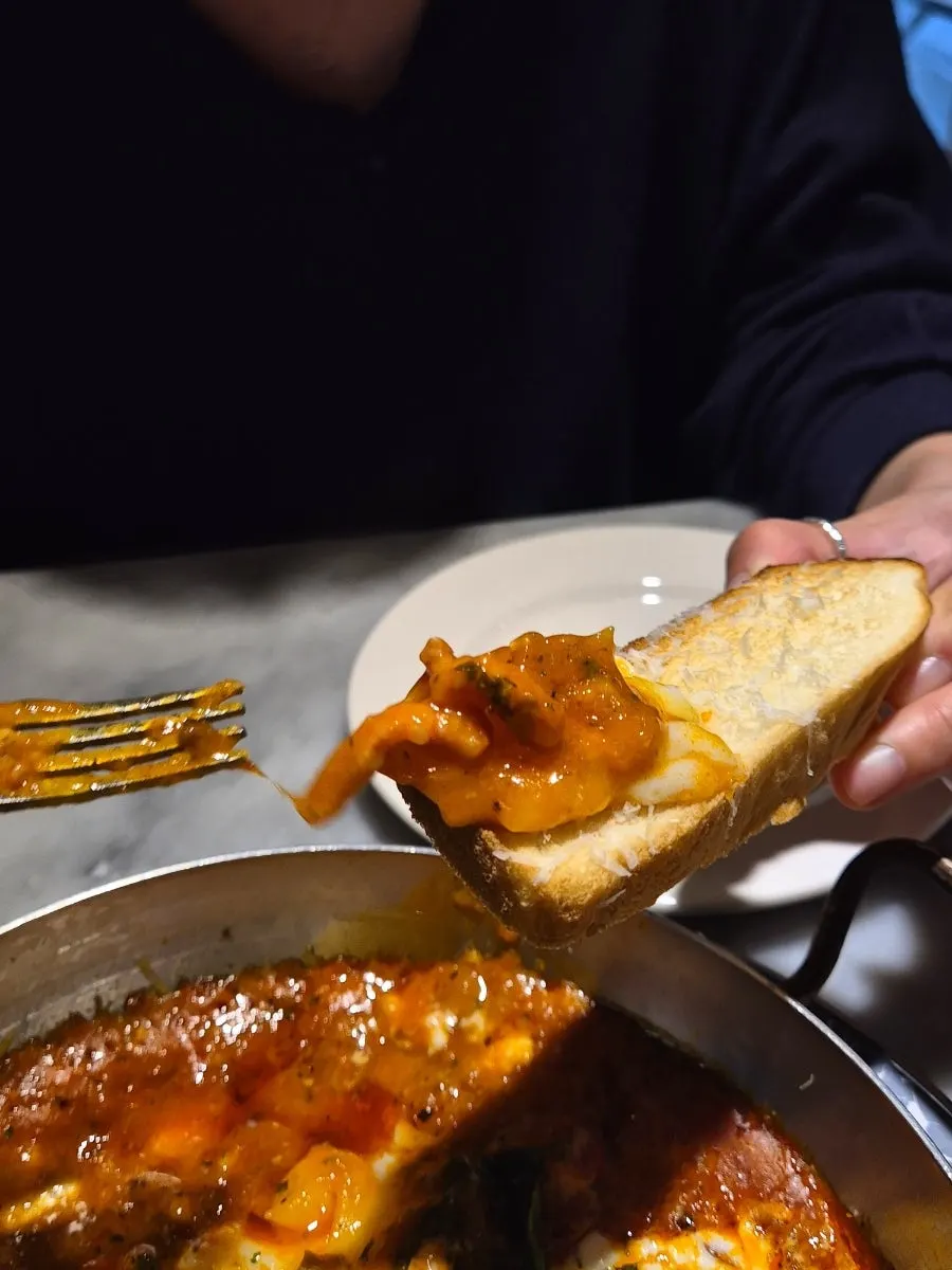 Yolk and tomato sauce spread over bread