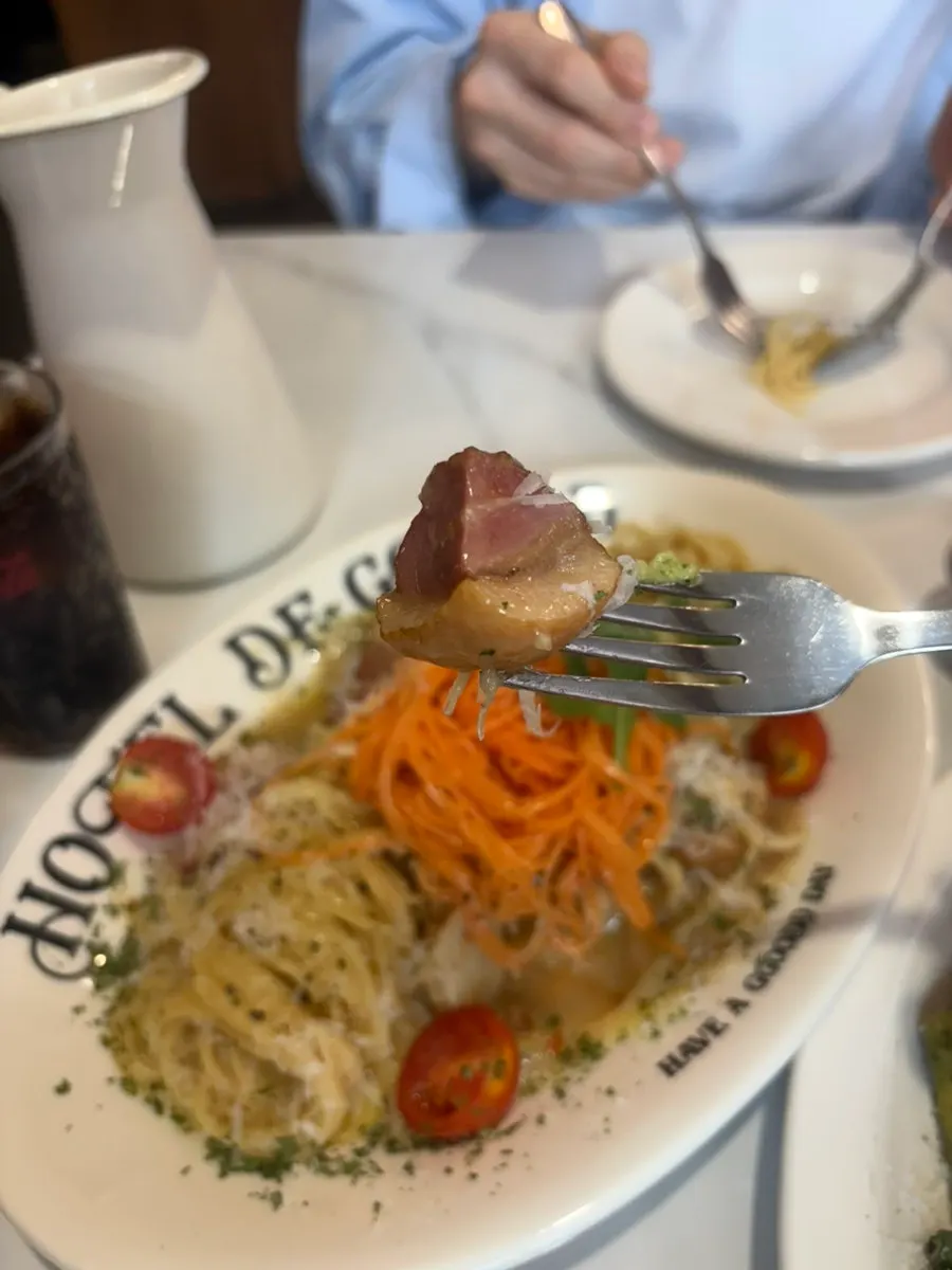 Carrot duck aglio olio topped with cheese powder and parsley