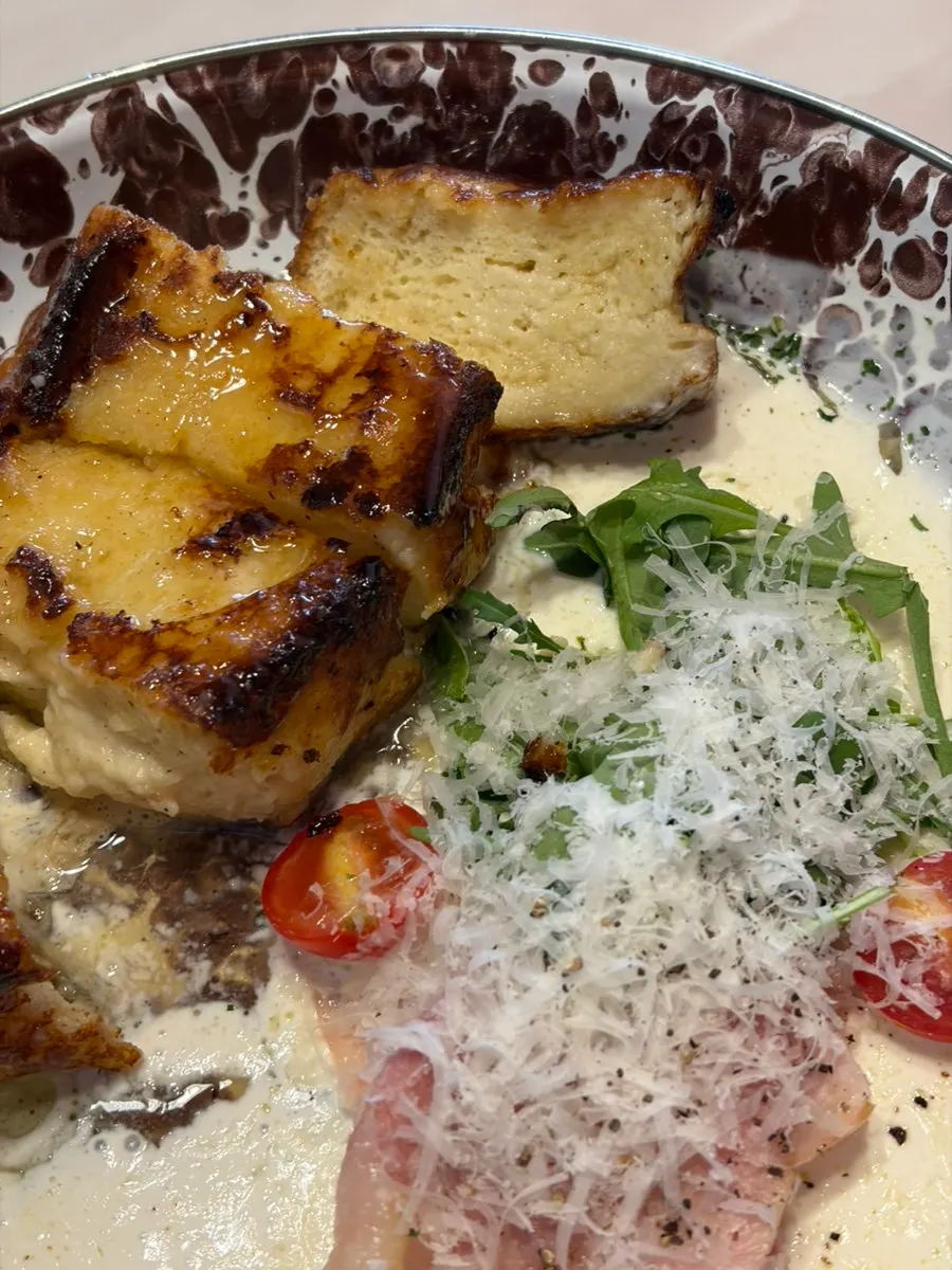 Cross-section of French toast topped with arugula and cheese