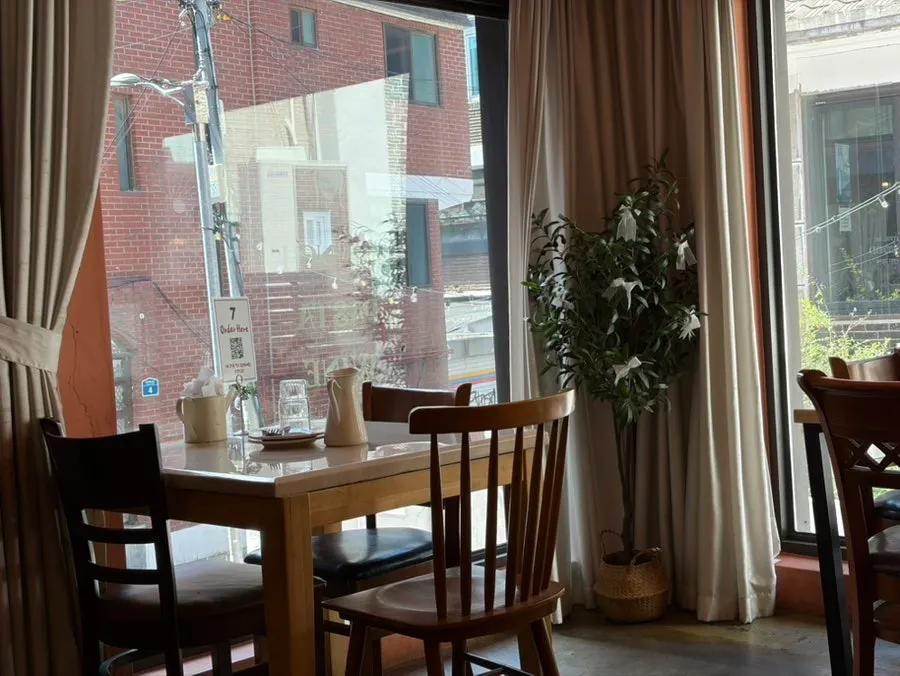 The dining hall at Hôtel de Couture lit by the floor-to-ceiling windows
