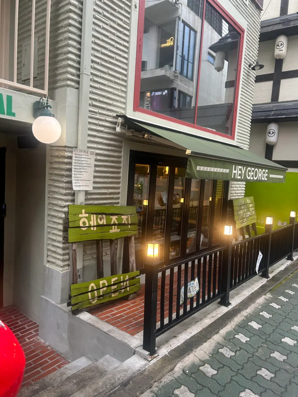 Exterior with the green-awning "HEY GEORGE" sign