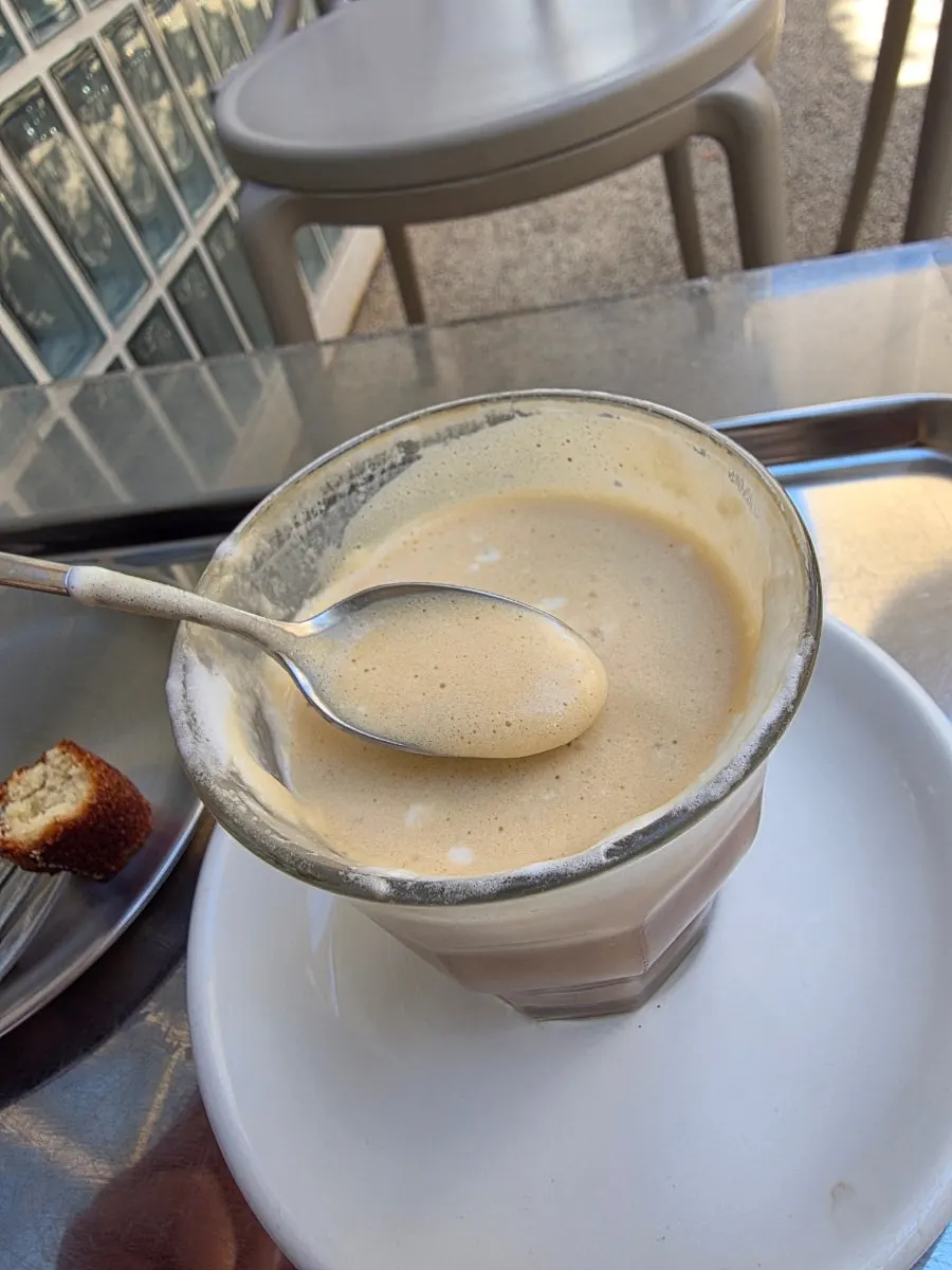 Pip Coffee stirred with a spoon to mix the cream and coffee