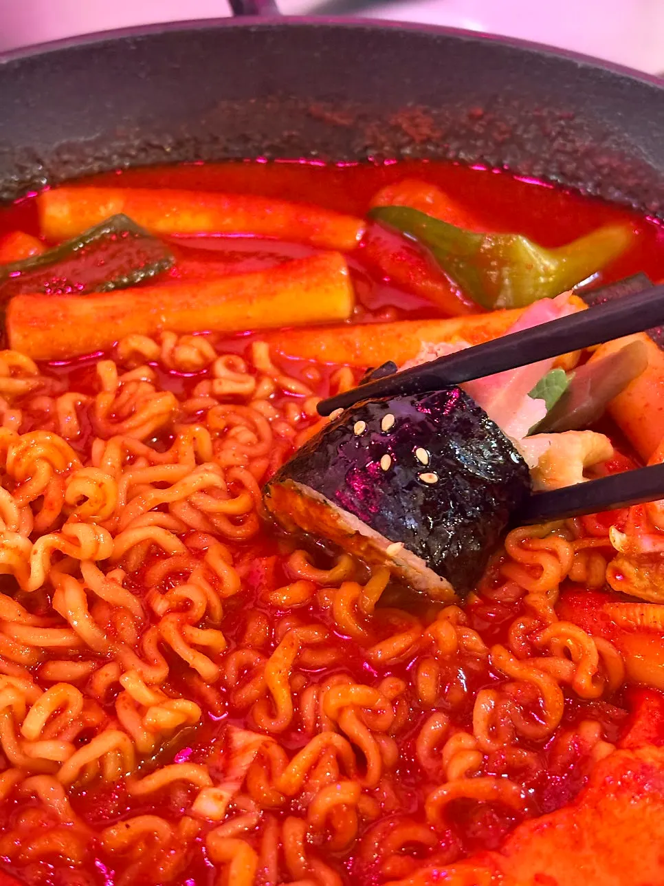 Mini gimbap dipped into tteokbokki sauce