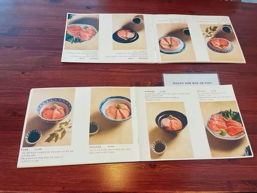 Menu board listing donburi, udon, and side dishes