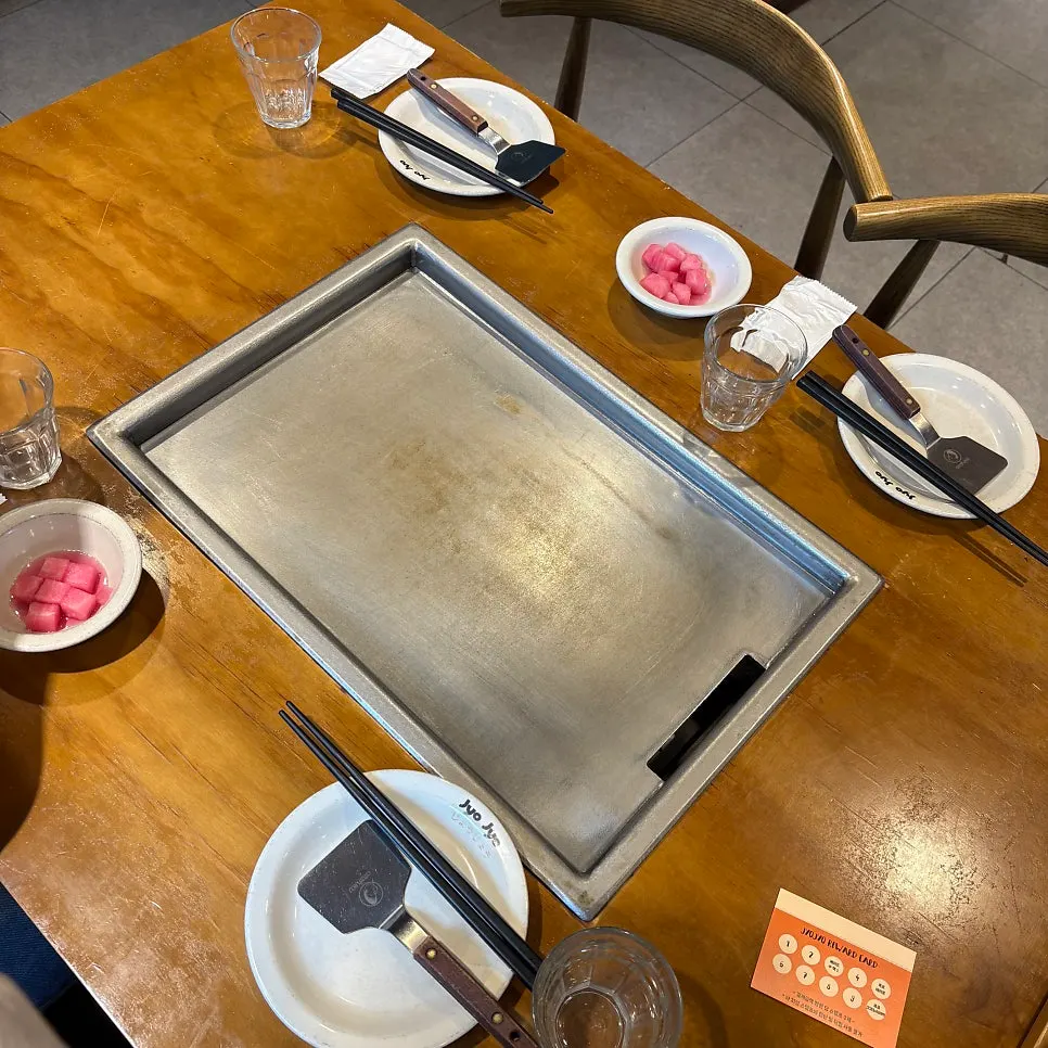 Large griddle being cooked on by a staff member