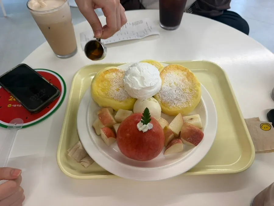 Peach soufflé pancake served with ice cream and cream