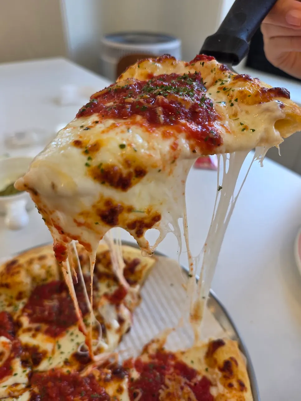 A slice of margherita pizza piled with cheese
