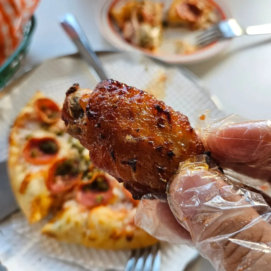 A slice of pepperoni pizza dipped in garlic sauce