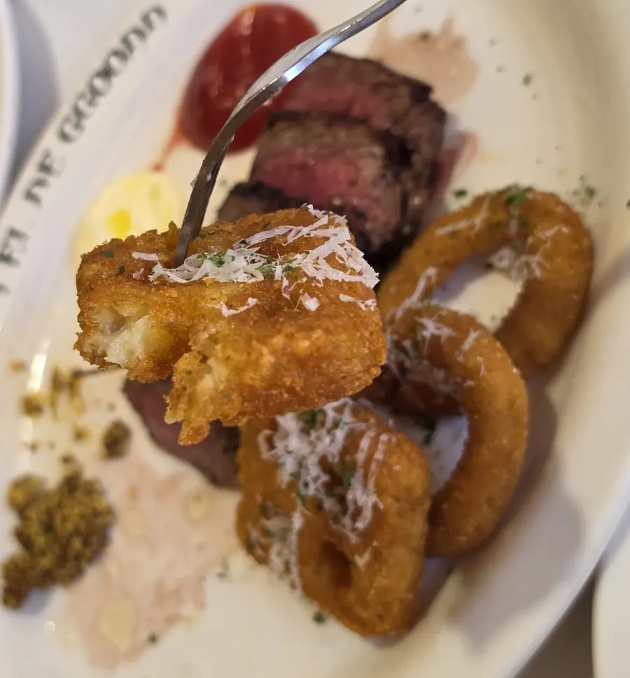 Close-up of crispy onion rings and hash browns