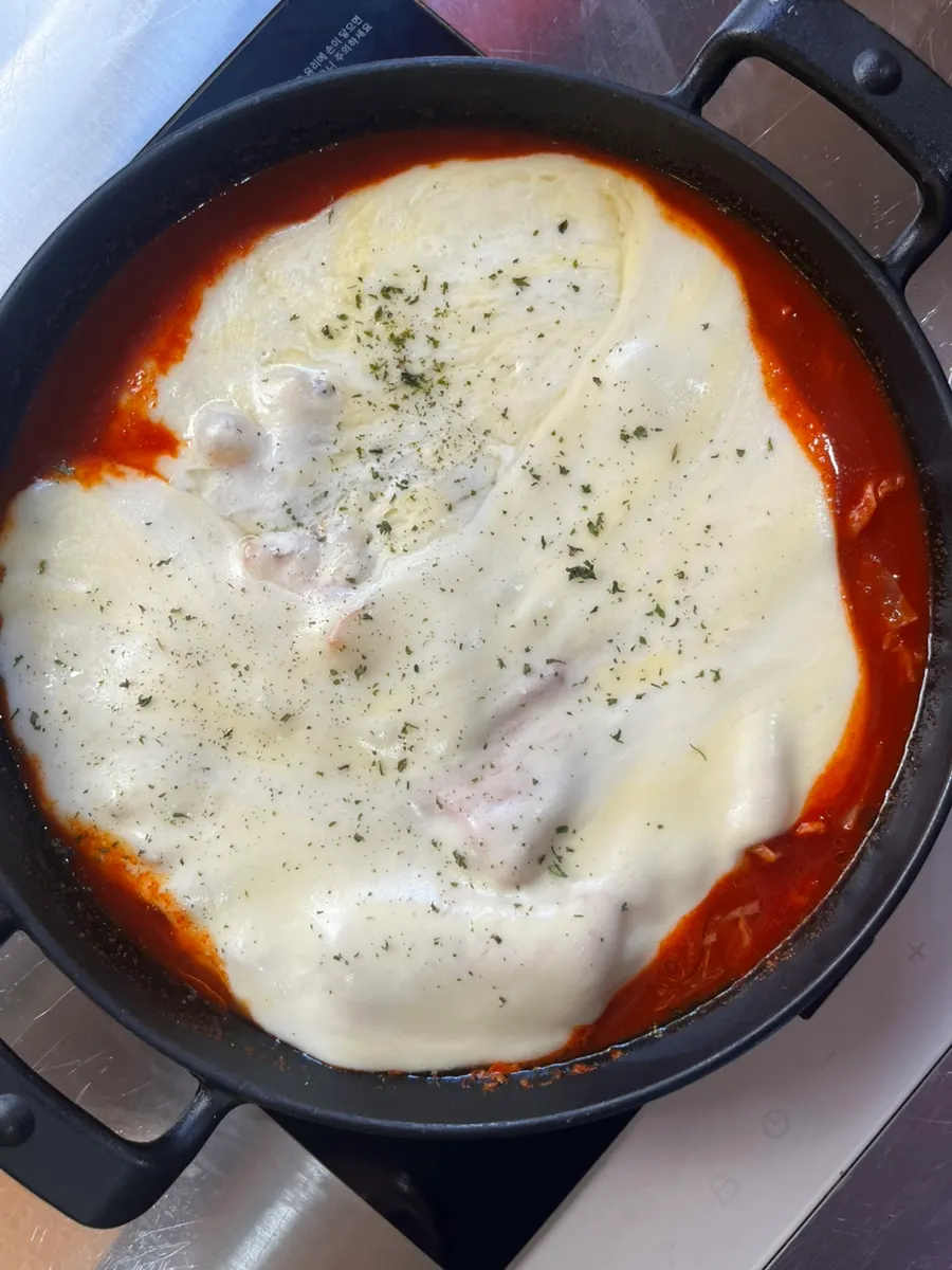 A pan of Eungkeum tteokbokki topped with mozzarella cheese