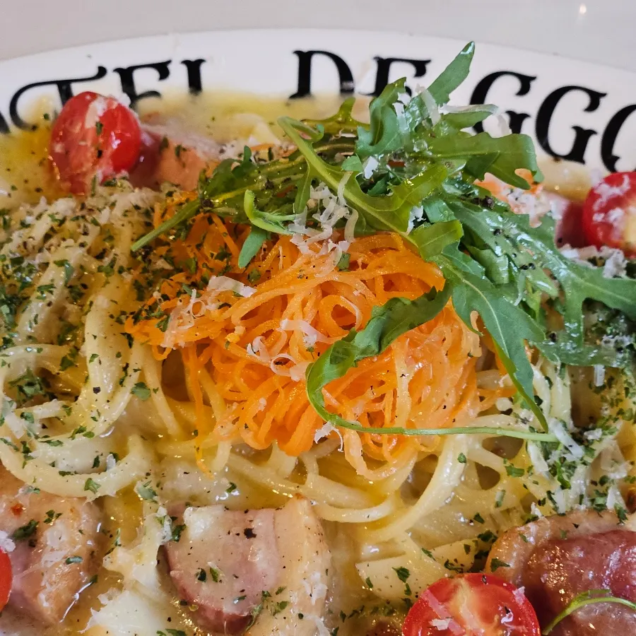 Duck pasta topped with julienned sautéed carrot