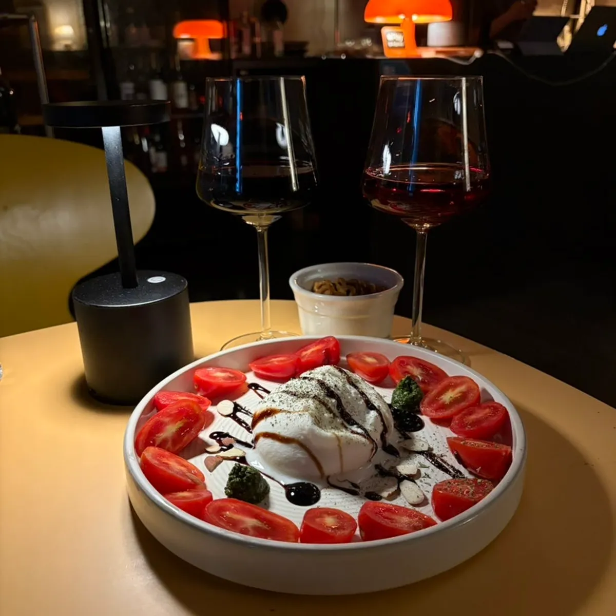 Two glasses of wine and burrata caprese on the table