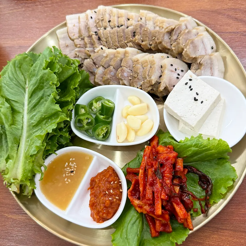 Small bossam served with vegetables and pickled radish strips