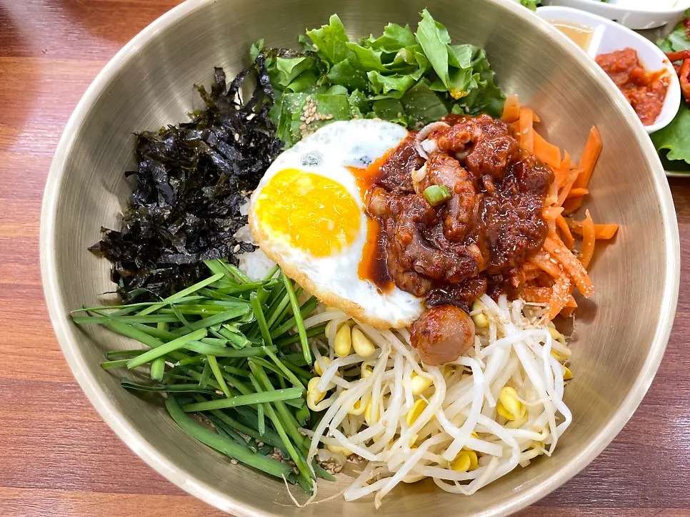 Pouring octopus seasoning over bibimbap to mix