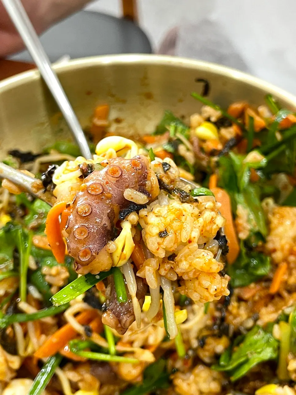 A spoonful of bibimbap topped with plump octopus