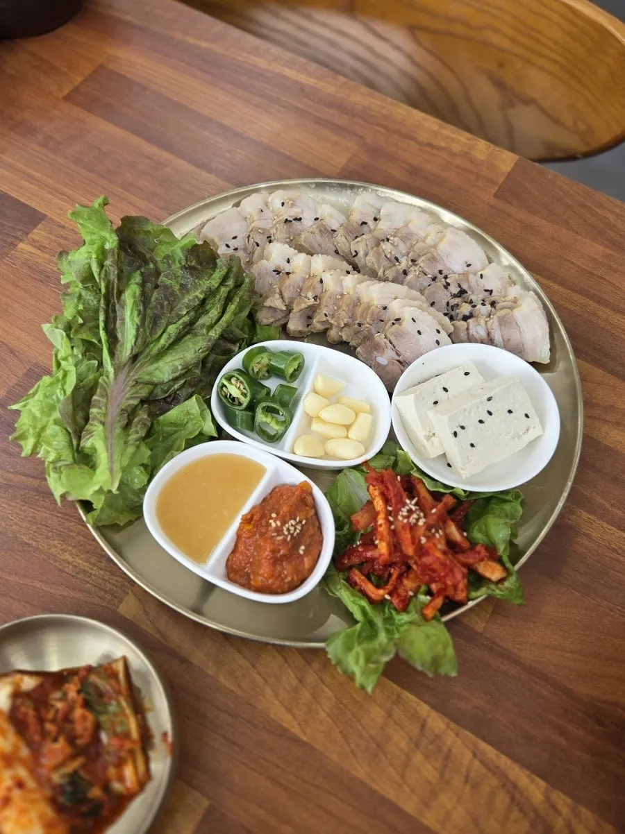 Small bossam plate with lettuce, garlic, and tofu on the side