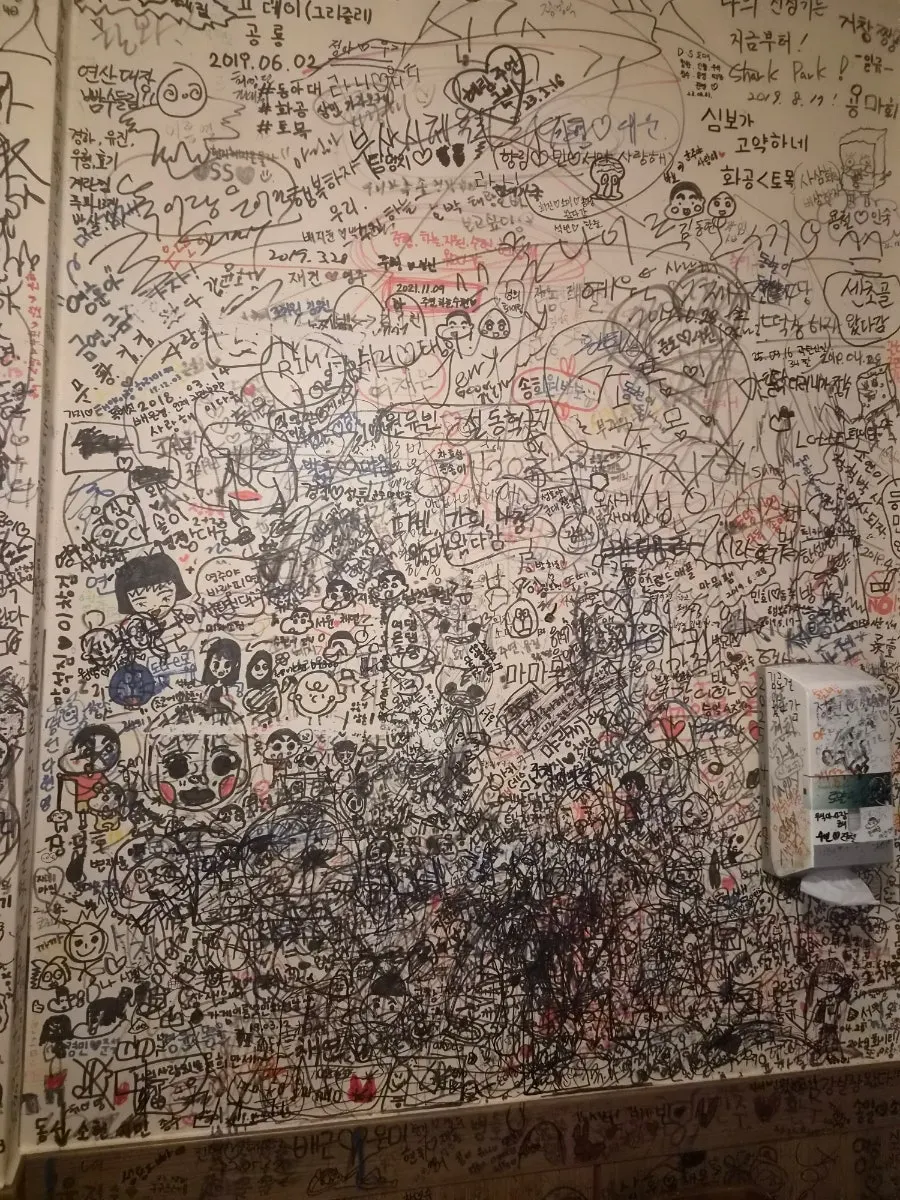 Names and drawings packed across the chicken pub wall