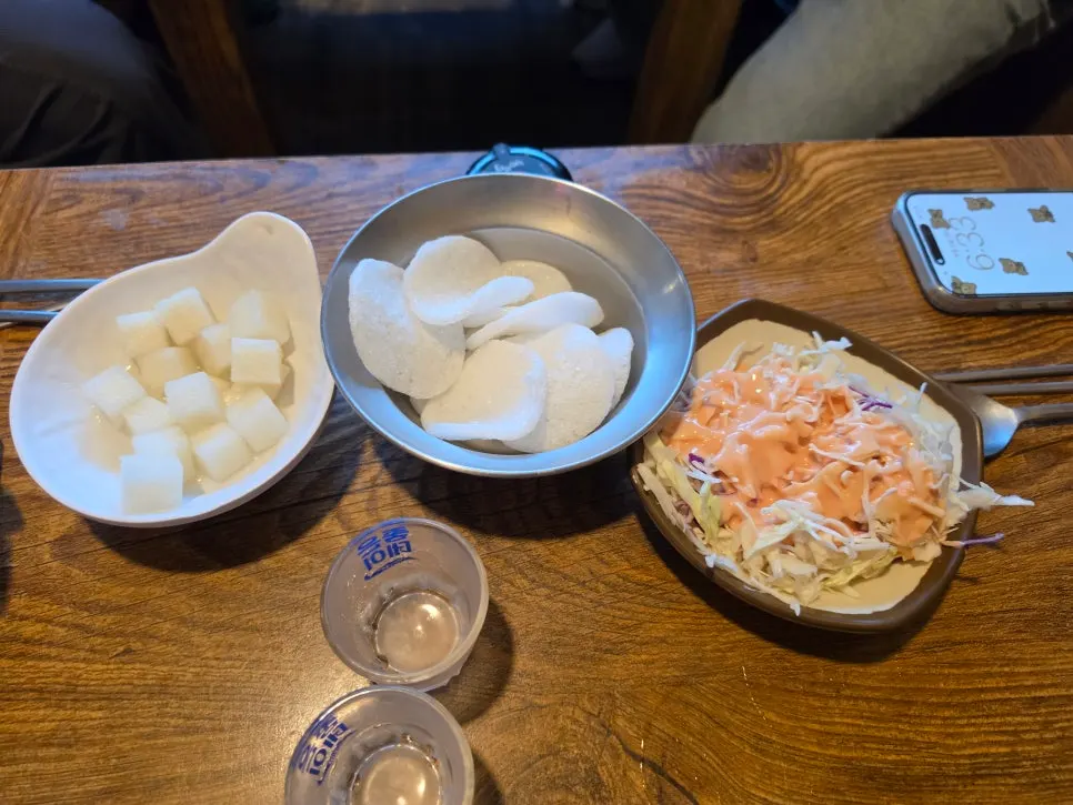 Basic table setting with pickled radish, cabbage salad, and egg chips