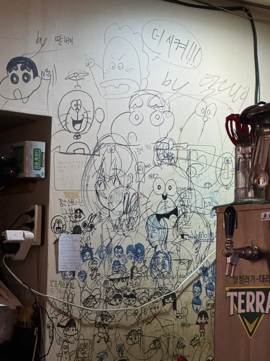 Graffiti-covered wall and tables inside Yetnal Tongdak & Tang
