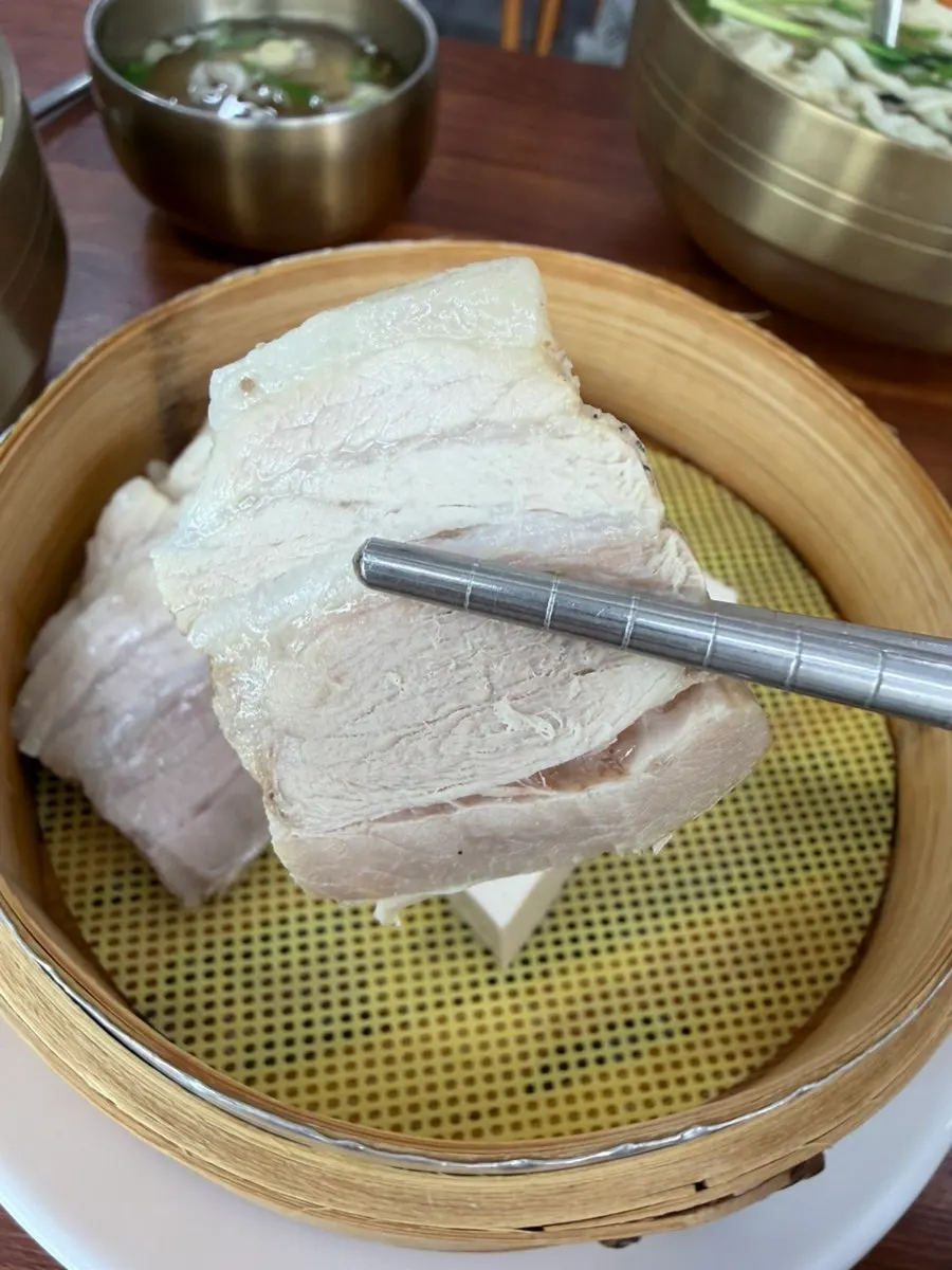 보쌈과 김치를 곁들인 칼국수 식사