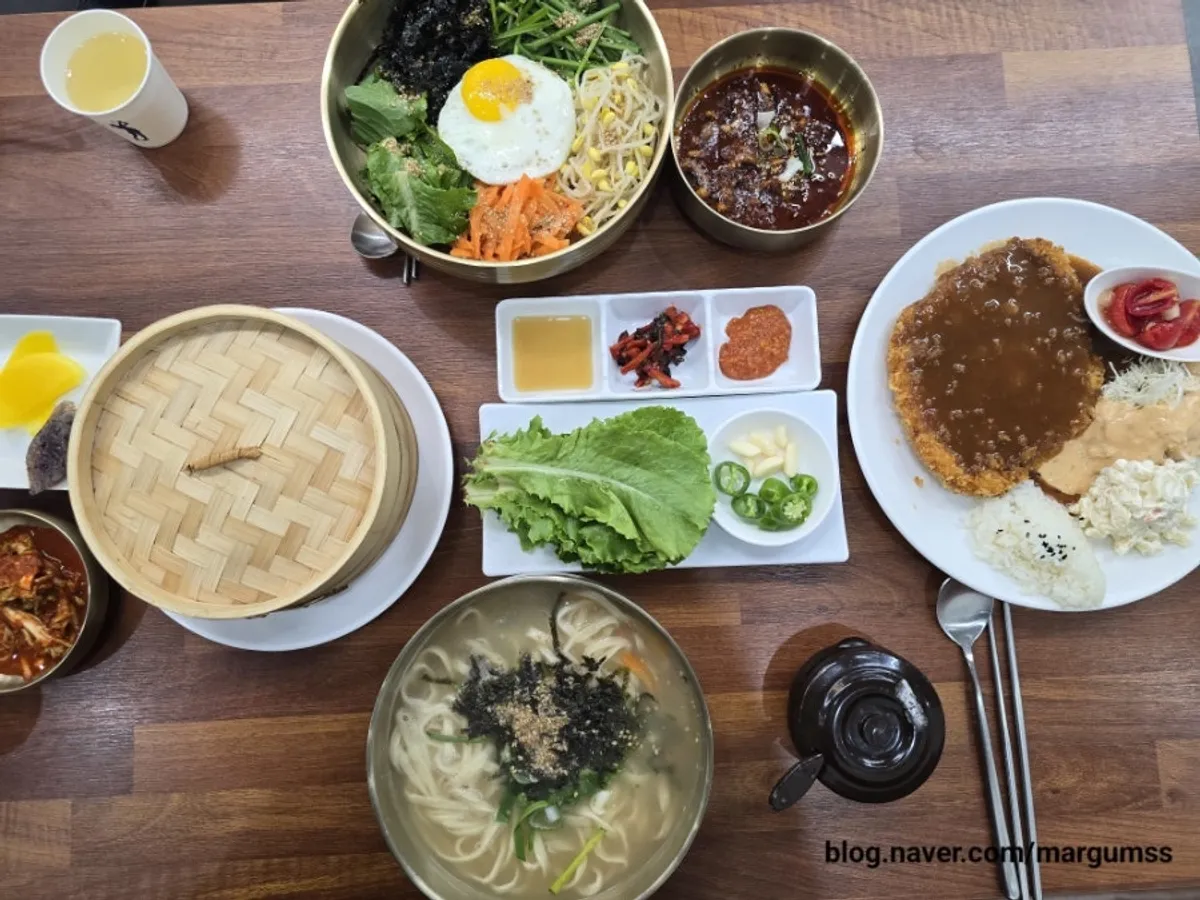 Full spread of kalguksu, bibimbap, bossam, and pork cutlet