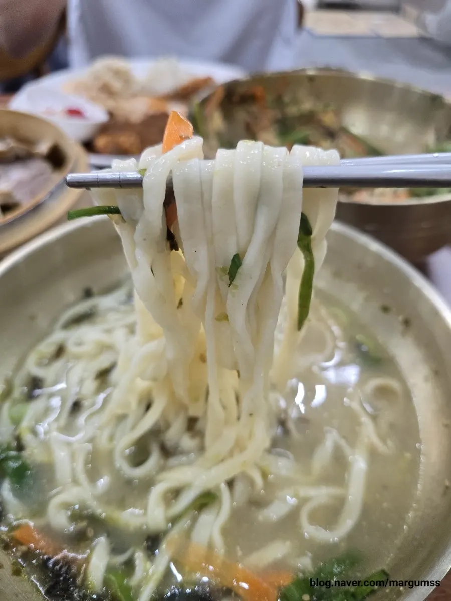 Eating kalguksu broth alongside pork cutlet