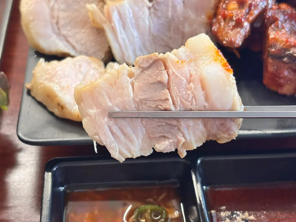 젓가락으로 집어 올린 보쌈 한 점