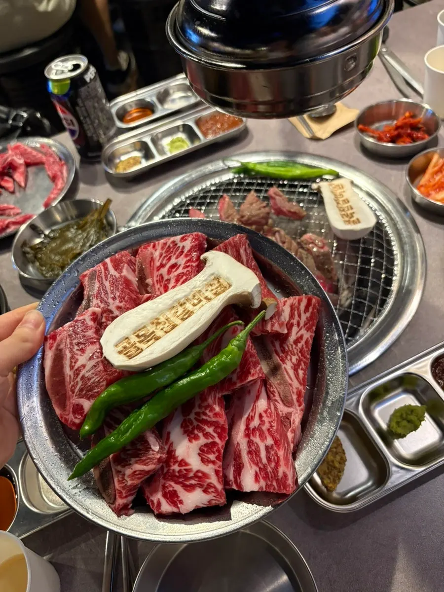 A piece of grilled beef galbisal dipped in salt