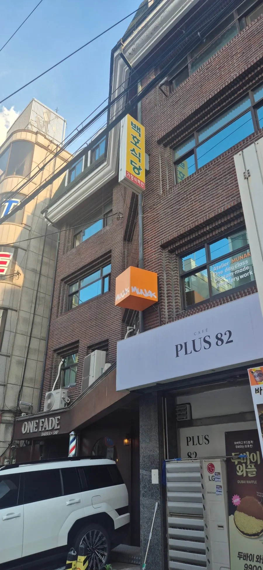Orange sign for Munak workshop on the 2nd floor of a commercial building
