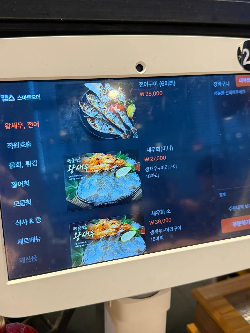 Menu board listing gizzard shad and raw shrimp sashimi