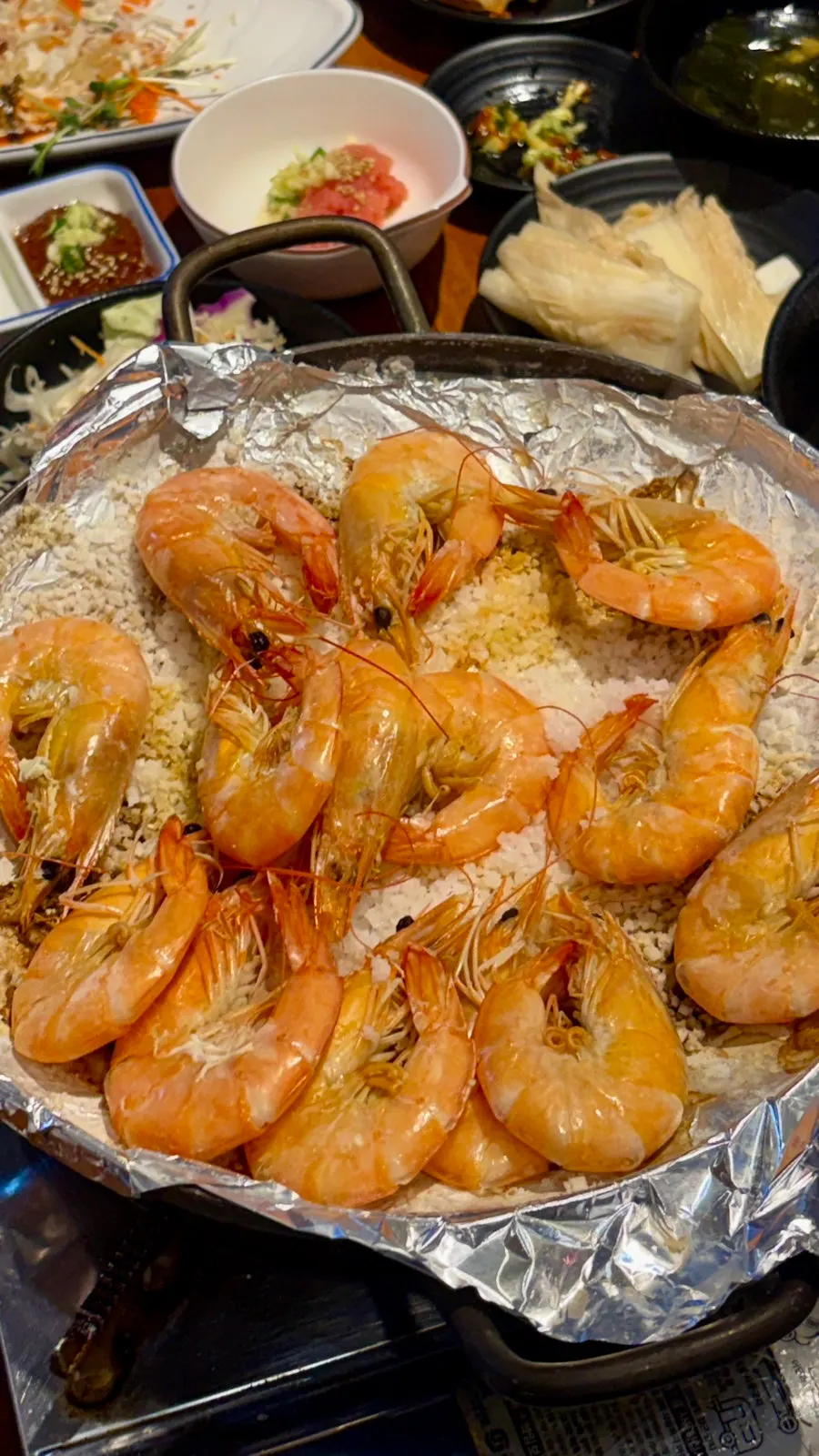 Raw shrimp grilling on a bed of salt