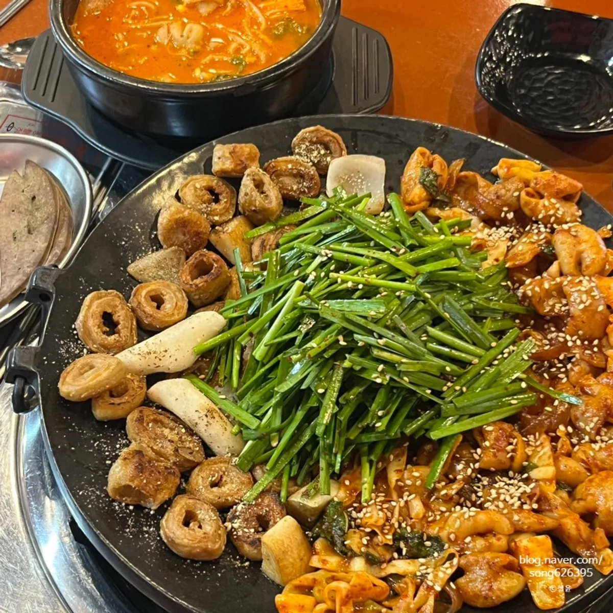 A spoonful of gopchang hot pot with perilla leaves and enoki mushrooms