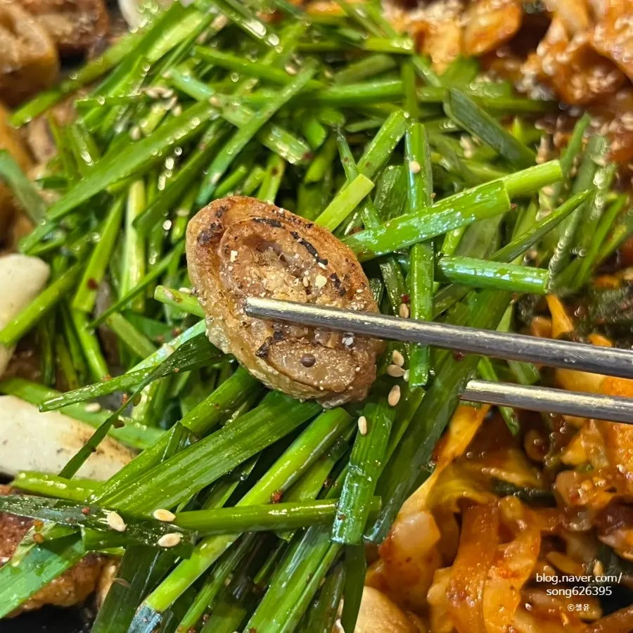 Gopchang and makchang on the grill topped with chives