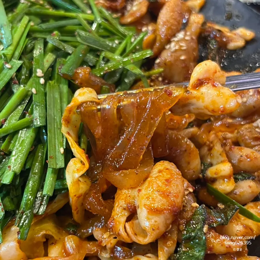 A piece of makchang picked up with chopsticks