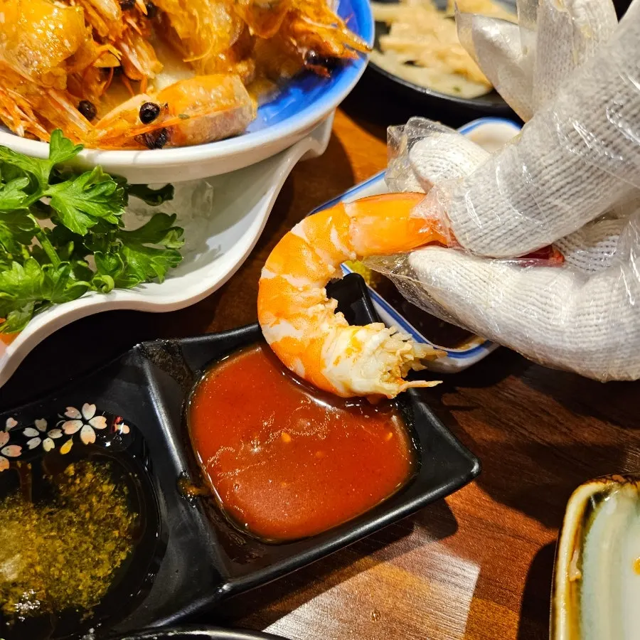 Peeling the shell off a fully cooked salt-grilled raw shrimp