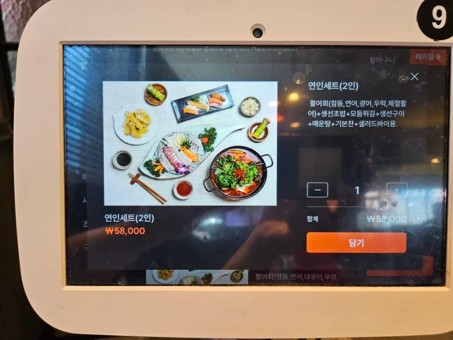 테이블에 놓인 주문용 태블릿과 리뷰 이벤트 안내