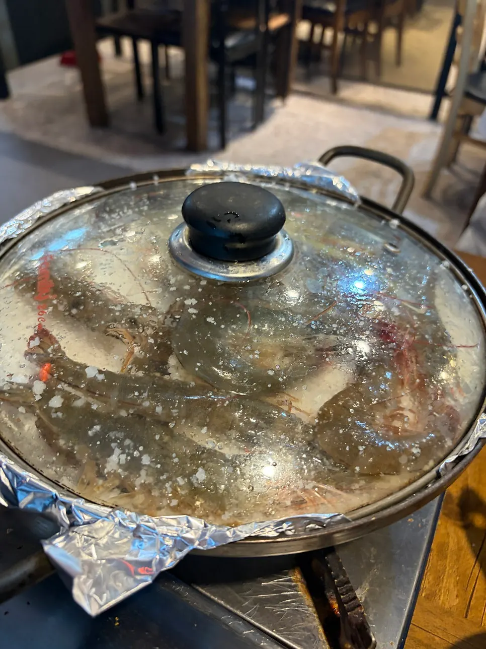 Grilled raw shrimp arriving with the pot lid still on
