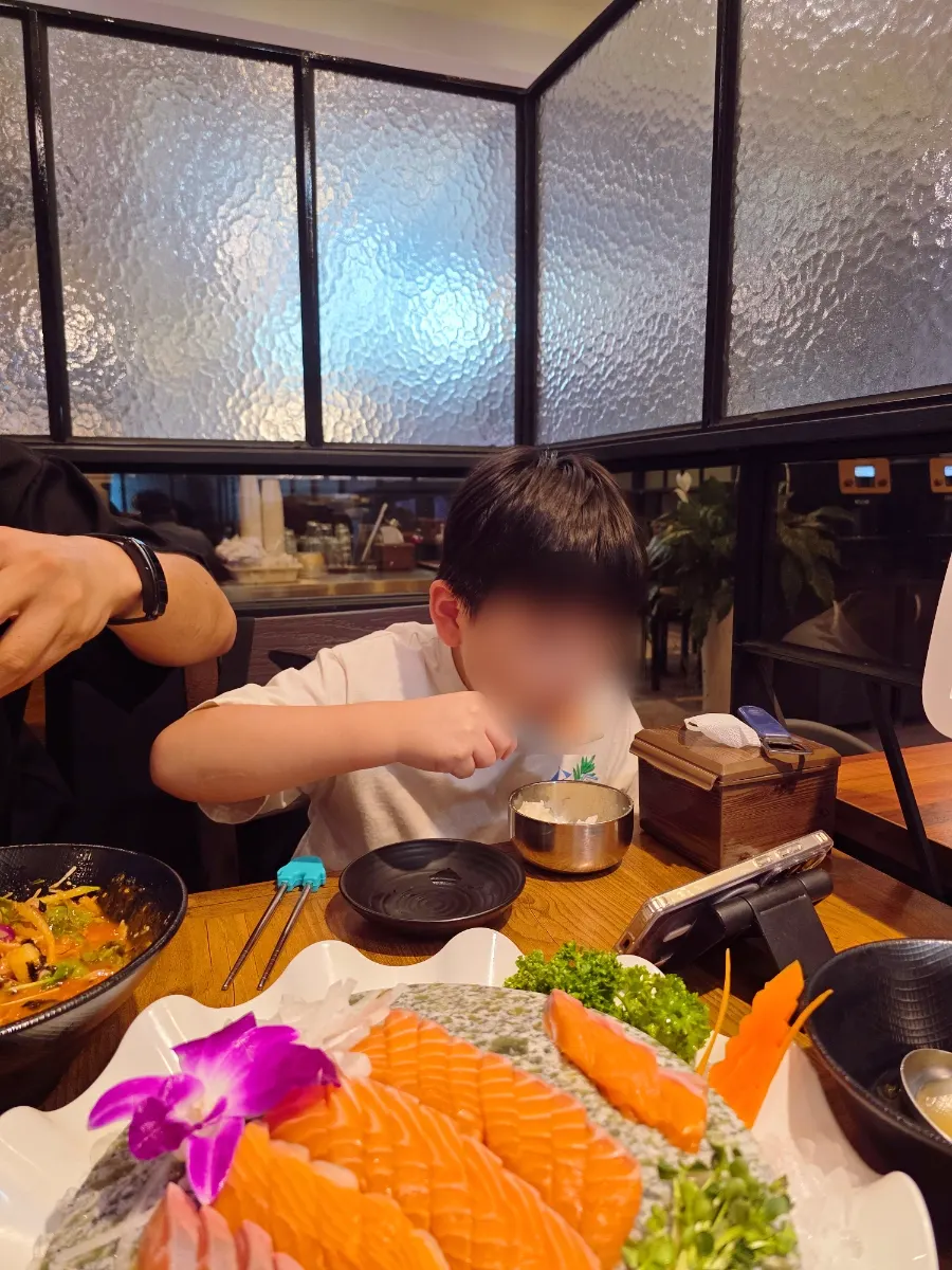 サーモン刺身を食べる子供