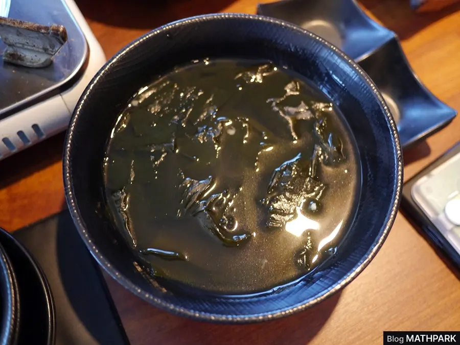 Kimchi pancake being fried on a gas burner