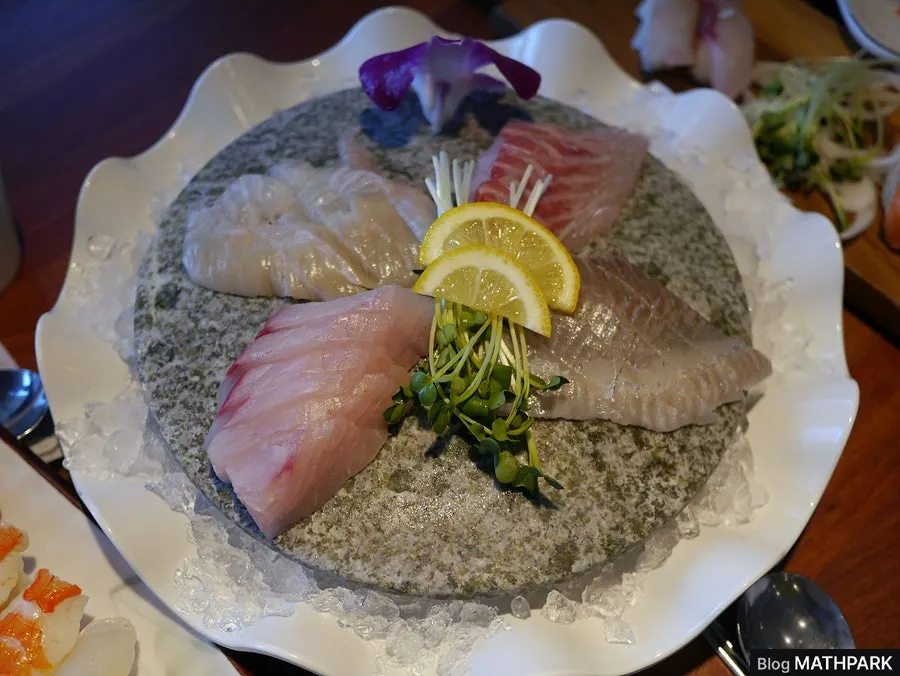 Table setting with pollack seaweed soup, raw fish mix, and fried food on the side
