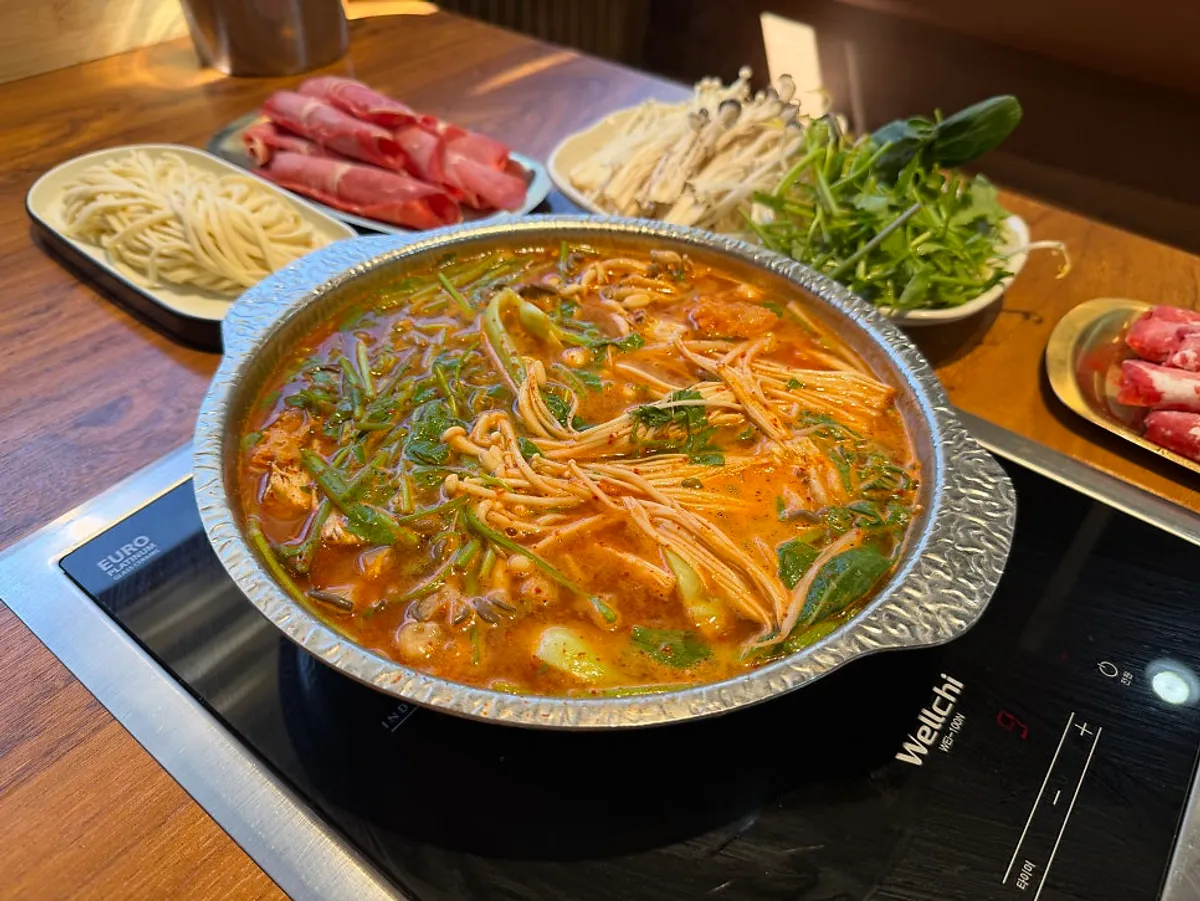 Full spread of Yeonsuok's spicy broth with vegetables and meat added