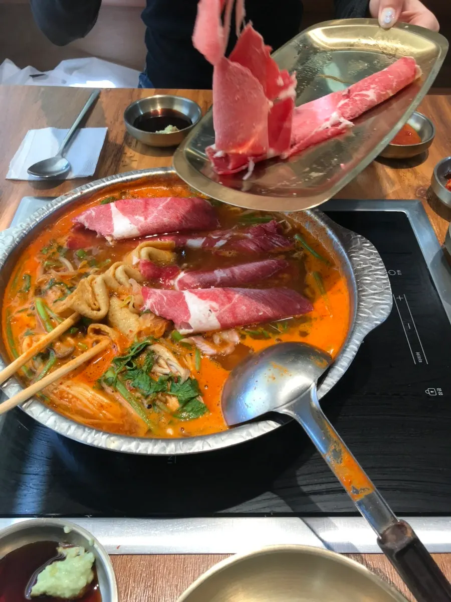 Table set with the boiled pork shabu kalguksu and seafood pancake order