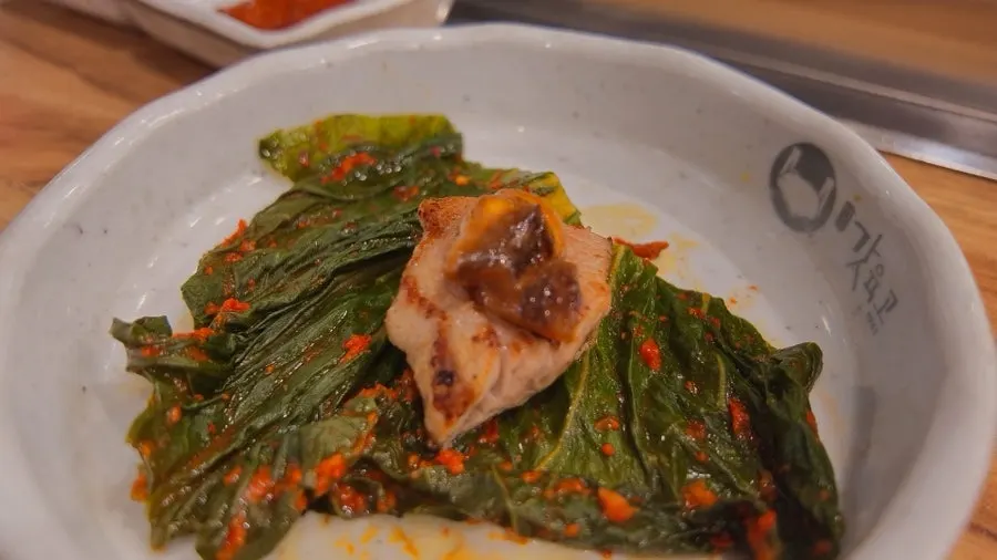 A piece of samgyeopsal and mokssal with sauce