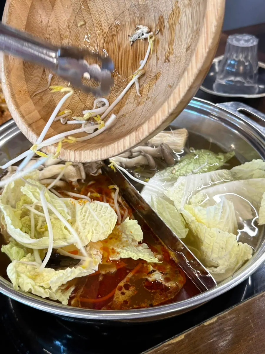Vegetables being added to the boiling broth