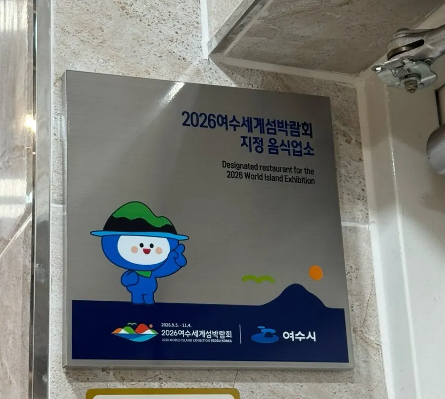 통큰샤브 입구 벽면의 여수세계섬박람회 지정 음식업소 명패